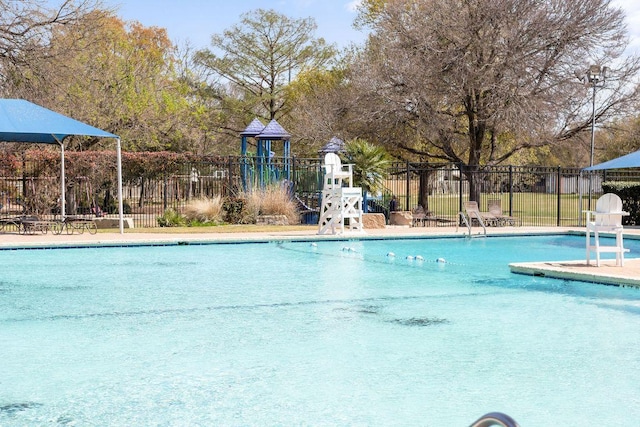 community pool featuring fence and playground community