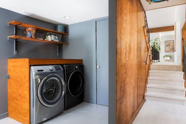clothes washing area with independent washer and dryer, light tile patterned flooring, and laundry area