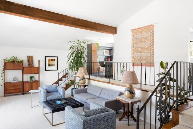 carpeted living area with vaulted ceiling with beams and stairway