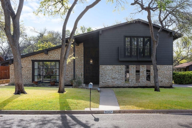 view of front of home with stone siding and a front lawn