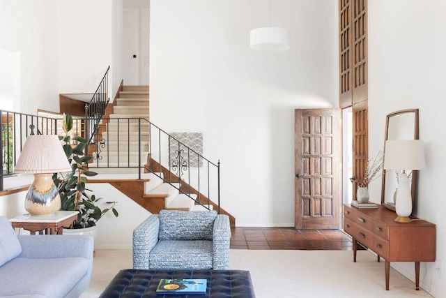 living room with stairs, a high ceiling, baseboards, and tile patterned floors