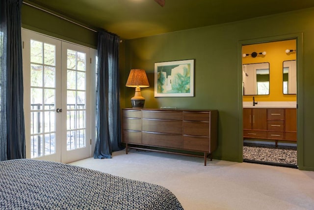 bedroom featuring french doors, a sink, access to exterior, light carpet, and ensuite bathroom