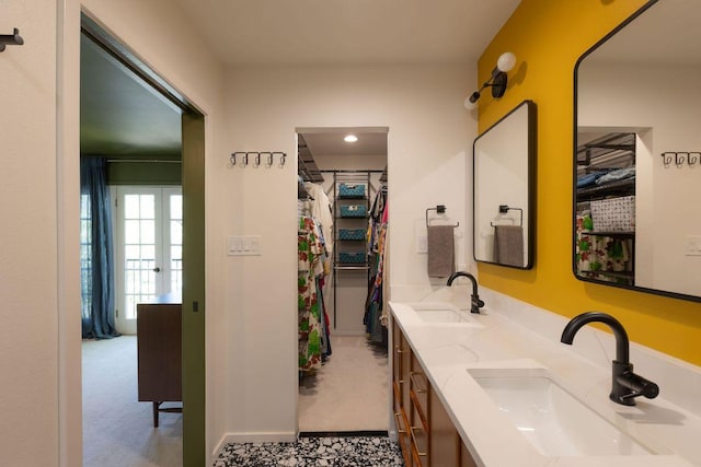 full bathroom featuring double vanity, a spacious closet, and a sink