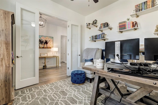 212 Tovas Secret Cv, Georgetown, TX 78628 - office area featuring baseboards, wood finished floors, and ceiling fan with notable chandelier