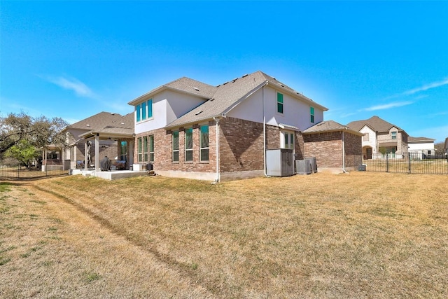 212 Tovas Secret Cv, Georgetown, TX 78628 - back of property featuring brick siding, fence, a patio, and a lawn
