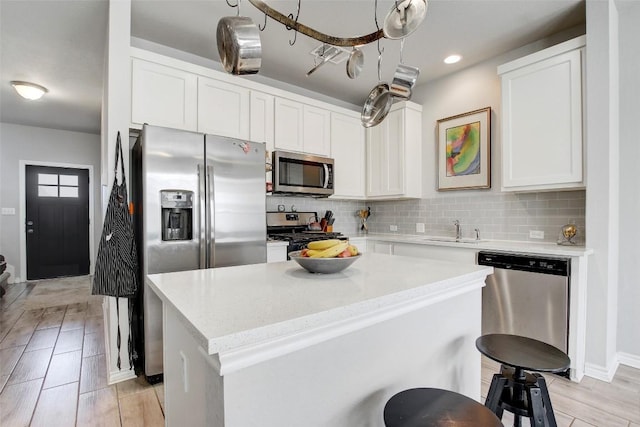 1813 Artesian Springs Xing, Leander, TX 78641 - kitchen with appliances with stainless steel finishes, a kitchen island, backsplash, a sink, and white cabinets