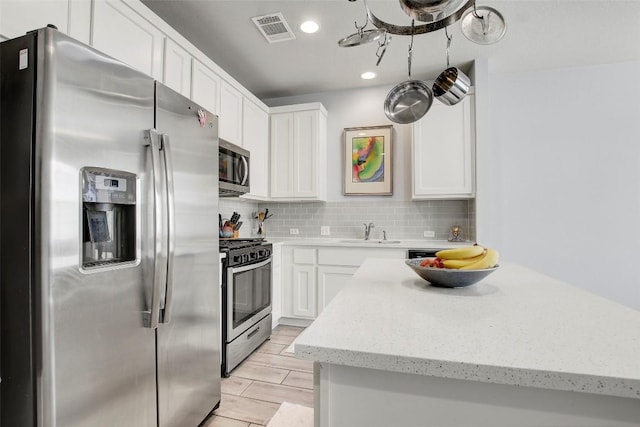 1813 Artesian Springs Xing, Leander, TX 78641 - kitchen with appliances with stainless steel finishes, white cabinets, backsplash, and recessed lighting