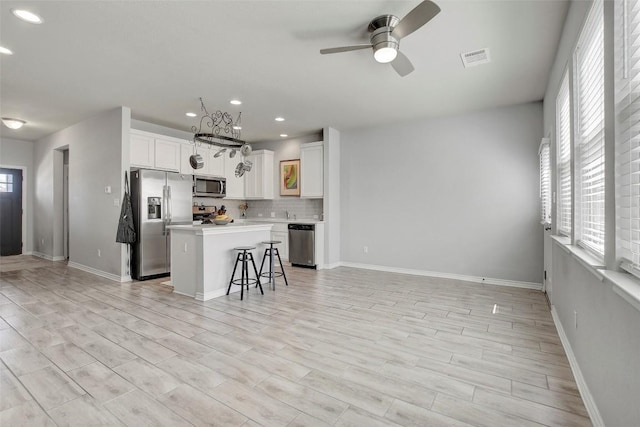 1813 Artesian Springs Xing, Leander, TX 78641 - kitchen with stainless steel appliances, ceiling fan, recessed lighting, decorative backsplash, and white cabinets