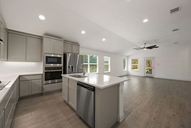 21203 Santa Rosa Ave, Lago Vista, TX 78645 - kitchen with appliances with stainless steel finishes, gray cabinets, lofted ceiling, wood finished floors, and light countertops