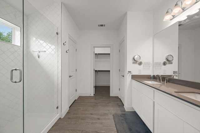 21203 Santa Rosa Ave, Lago Vista, TX 78645 - bathroom with wood finished floors, double vanity, a stall shower, and a spacious closet