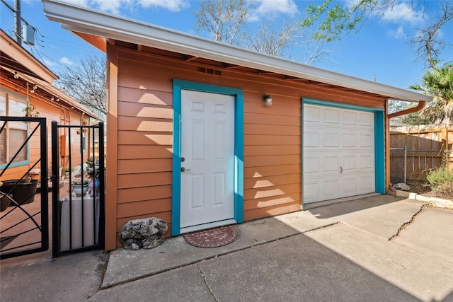 garage with driveway and fence