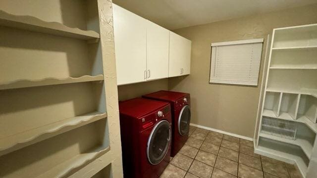 washroom featuring baseboards, cabinet space, tile patterned floors, and washer and dryer
