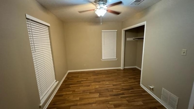 unfurnished bedroom with baseboards, visible vents, a closet, and wood finished floors