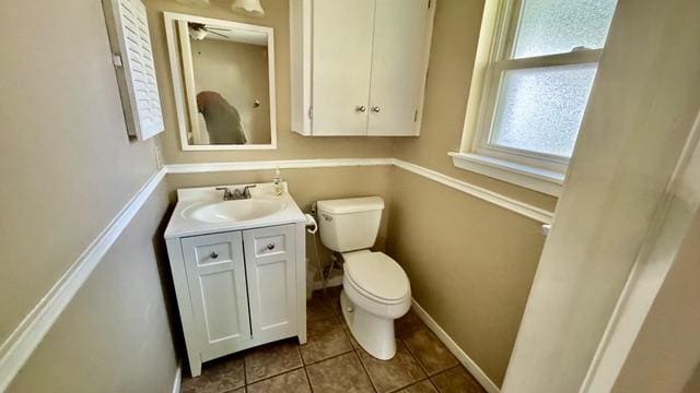 bathroom with baseboards, toilet, tile patterned flooring, and vanity