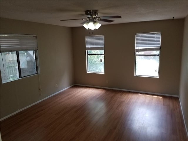 unfurnished room featuring wood finished floors, baseboards, and ceiling fan