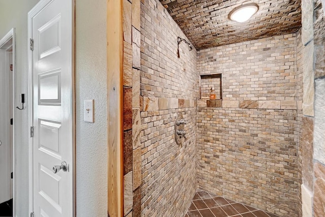 full bathroom featuring a tile shower and brick ceiling