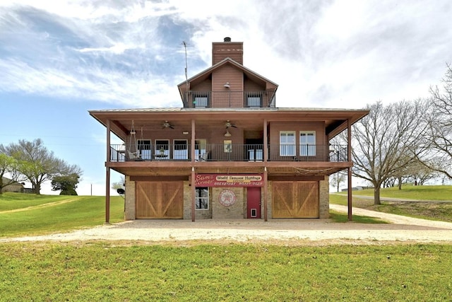 back of house with a lawn, a chimney, and ceiling fan