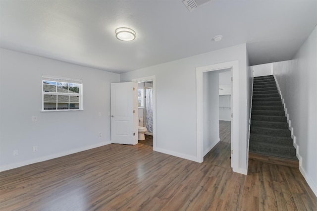 155 Travis Ln, Spicewood, TX 78669 - unfurnished bedroom featuring multiple windows, wood finished floors, a spacious closet, and baseboards