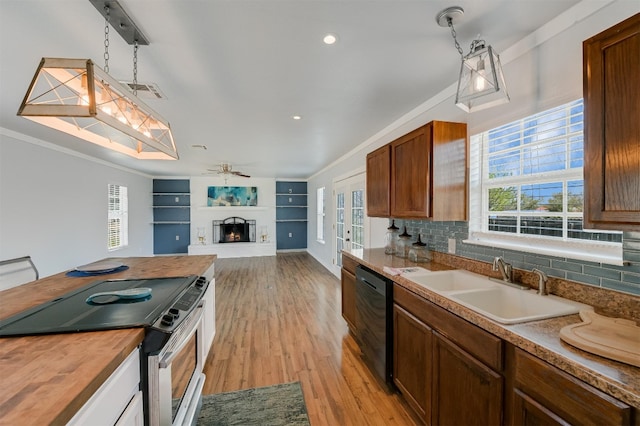 155 Travis Ln, Spicewood, TX 78669 - kitchen featuring electric range, wooden counters, dishwasher, a sink, and a lit fireplace
