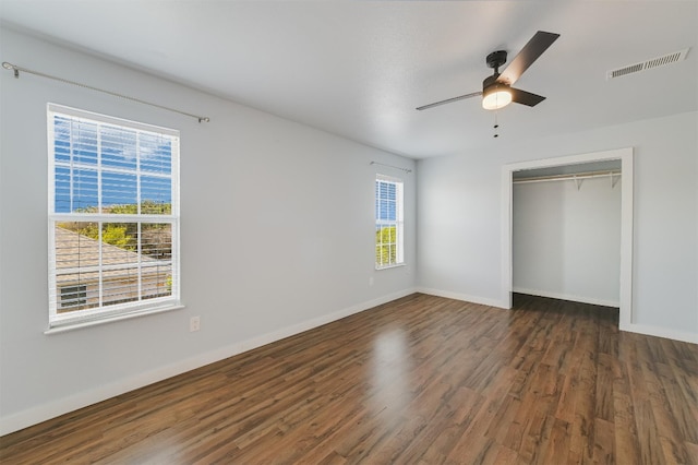 155 Travis Ln, Spicewood, TX 78669 - unfurnished bedroom with wood finished floors, multiple windows, baseboards, and a closet