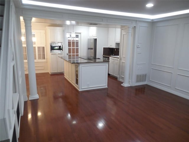 3501 Greystone Dr Unit 3501, Austin, TX 78731 - kitchen featuring stainless steel appliances, decorative columns, dark countertops, and dark wood-style floors