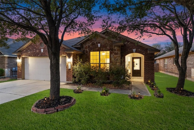471 Bayou Bend Dr, Buda, TX 78610 - view of front of property with driveway, an attached garage, a front yard, brick siding, and stone siding
