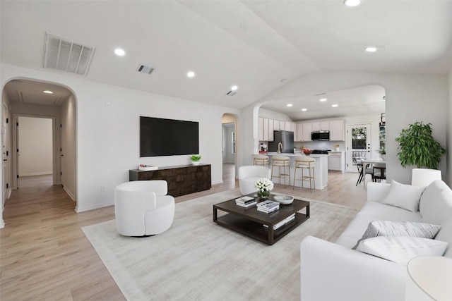 471 Bayou Bend Dr, Buda, TX 78610 - living room with arched walkways, lofted ceiling, light wood-type flooring, recessed lighting, and baseboards