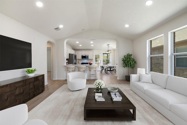471 Bayou Bend Dr, Buda, TX 78610 - living area with arched walkways, lofted ceiling, light wood finished floors, recessed lighting, and baseboards
