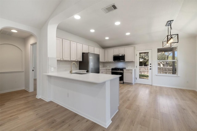 471 Bayou Bend Dr, Buda, TX 78610 - kitchen with appliances with stainless steel finishes, lofted ceiling, a sink, light countertops, and a peninsula