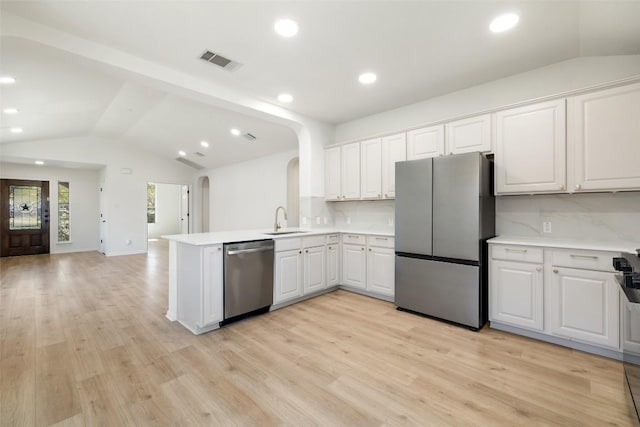 471 Bayou Bend Dr, Buda, TX 78610 - kitchen with stainless steel appliances, vaulted ceiling, arched walkways, light countertops, and open floor plan