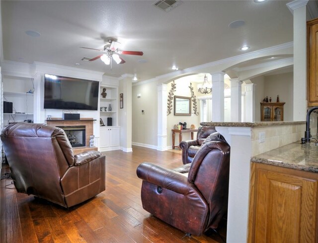 4209 N Sunflower Ln, Temple, TX 76502 - living area with decorative columns, ceiling fan, ornamental molding, a fireplace, and dark wood finished floors