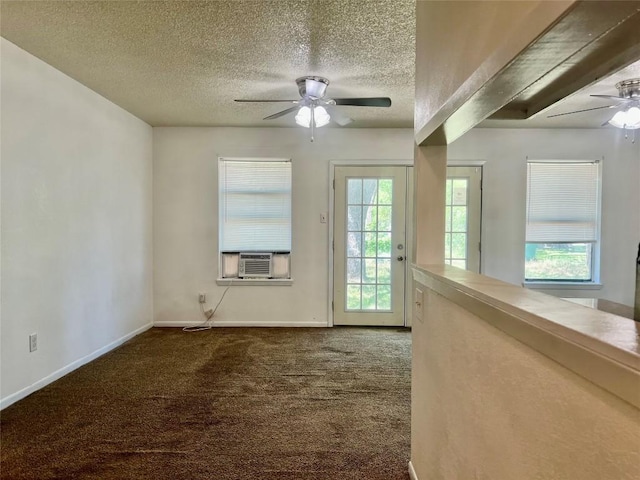 spare room featuring carpet, cooling unit, a textured ceiling, a ceiling fan, and baseboards