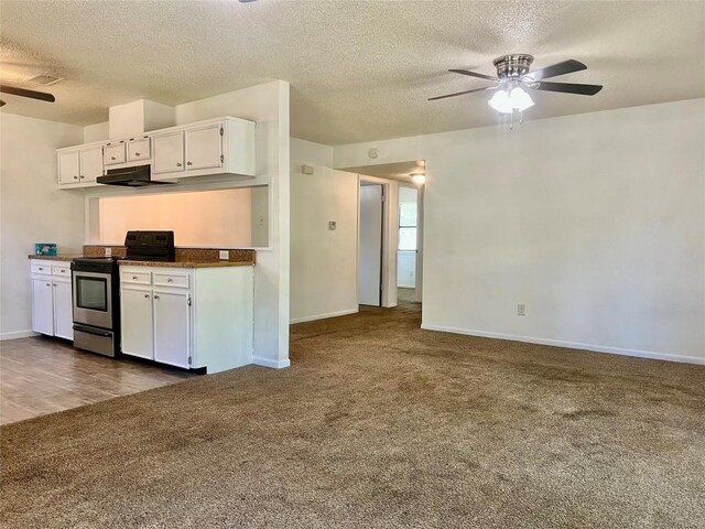 302 Harris St, Smithville, TX 78957 - kitchen featuring stainless steel range with electric cooktop, ceiling fan, dark carpet, under cabinet range hood, and white cabinetry