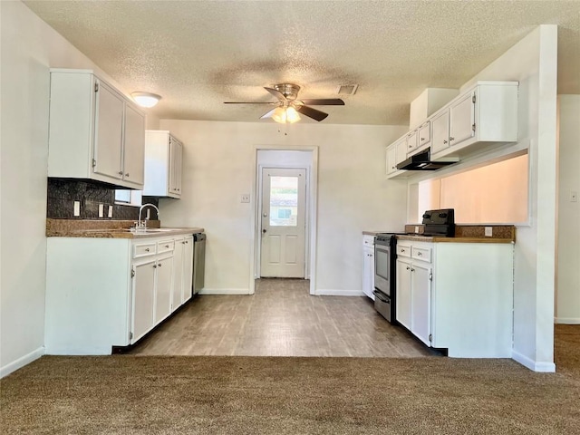 kitchen with a textured ceiling, ceiling fan, baseboards, and stainless steel appliances