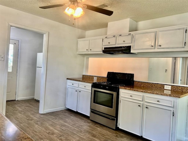 302 Harris St, Smithville, TX 78957 - kitchen with stainless steel electric stove, freestanding refrigerator, dark wood-style floors, under cabinet range hood, and white cabinets