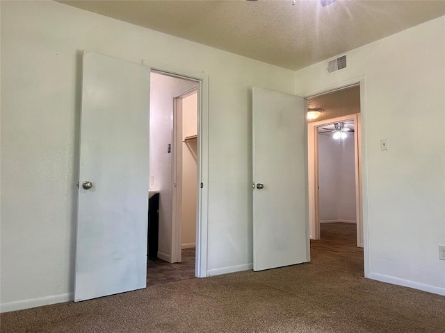 unfurnished bedroom with visible vents, baseboards, a textured ceiling, and carpet floors