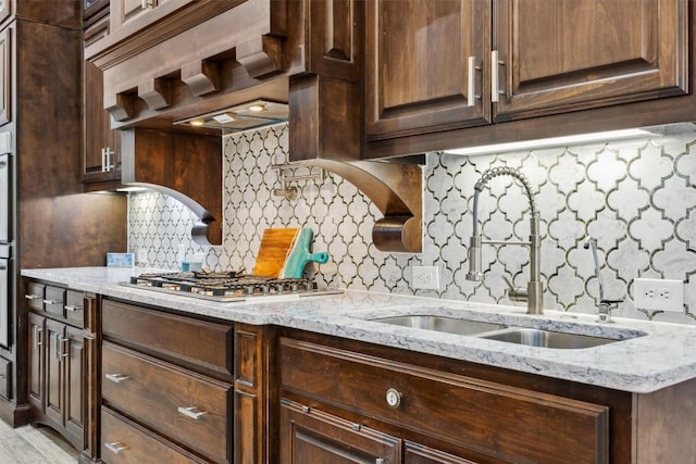 3801 Panther Hall, Leander, TX 78641 - kitchen with stainless steel appliances, dark brown cabinetry, light stone countertops, and backsplash