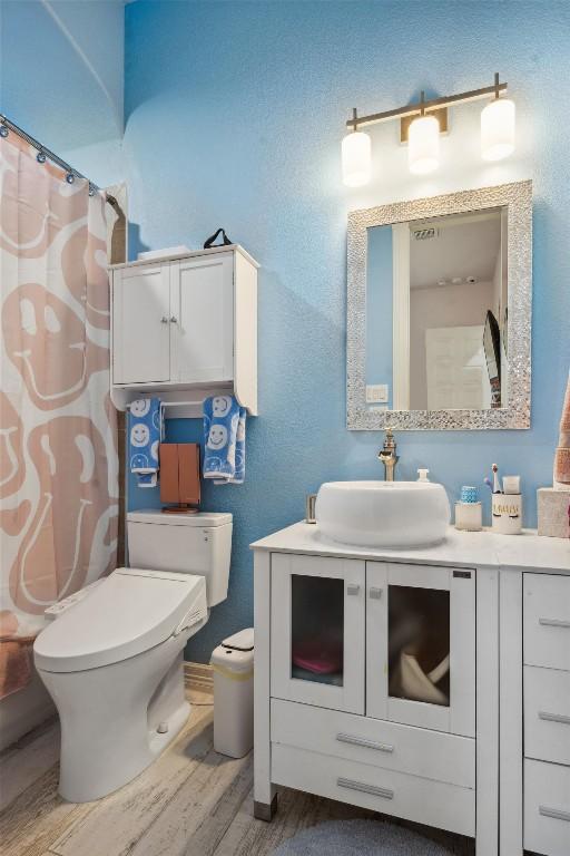 3801 Panther Hall, Leander, TX 78641 - full bathroom featuring vanity, wood finished floors, and a shower with shower curtain