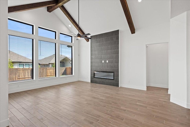 18716 Hopper Ln, Austin, TX 78738 - unfurnished living room with baseboards, beamed ceiling, high vaulted ceiling, and wood finished floors