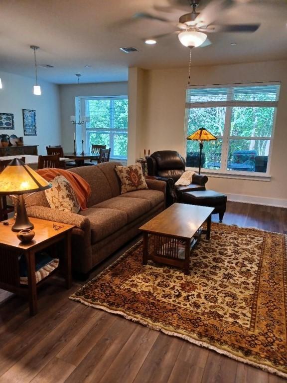 1717 Roseburg Dr, Austin, TX 78754 - living area featuring baseboards, visible vents, ceiling fan, and dark wood-type flooring