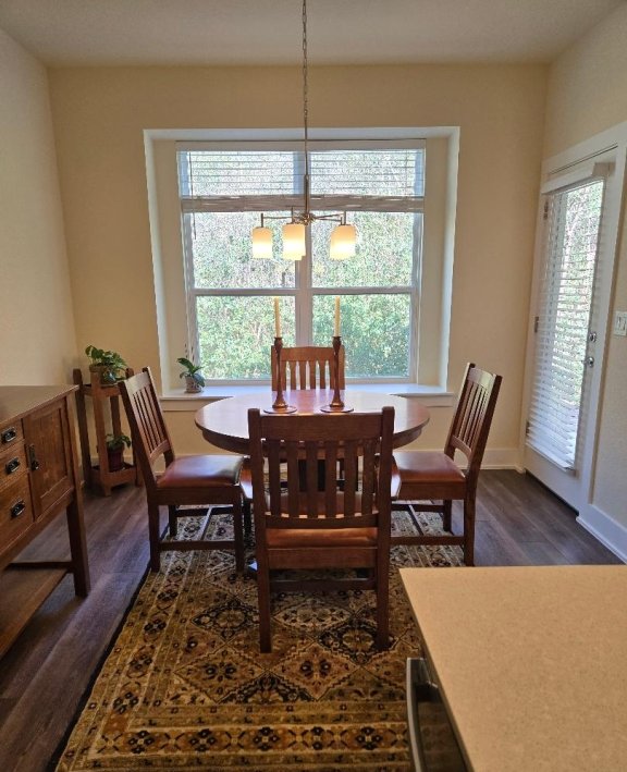 1717 Roseburg Dr, Austin, TX 78754 - dining area with baseboards, a notable chandelier, and dark wood-type flooring