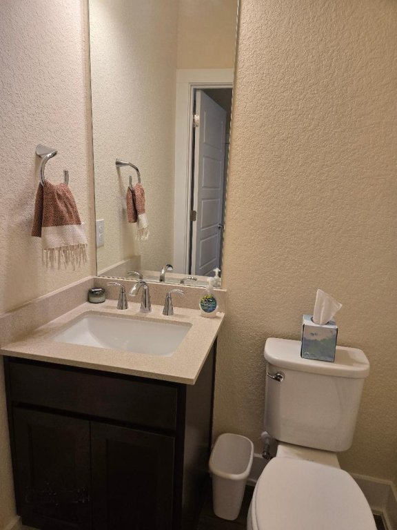 1717 Roseburg Dr, Austin, TX 78754 - bathroom with toilet, vanity, and a textured wall