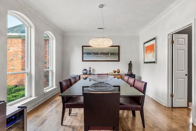 2807 Round Table Rd, Austin, TX 78746 - dining area with wood finished floors, ornamental molding, a chandelier, and wine cooler