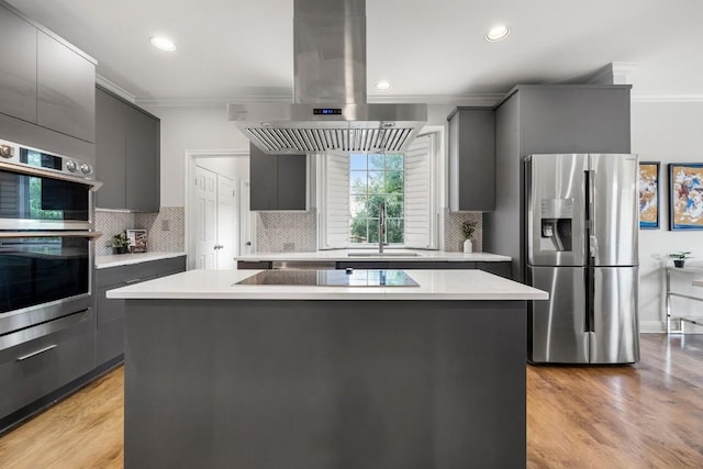 2807 Round Table Rd, Austin, TX 78746 - kitchen with appliances with stainless steel finishes, island range hood, ornamental molding, gray cabinets, and a kitchen island