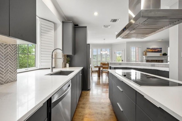2807 Round Table Rd, Austin, TX 78746 - kitchen featuring wall chimney range hood, stainless steel appliances, light countertops, gray cabinets, and modern cabinets