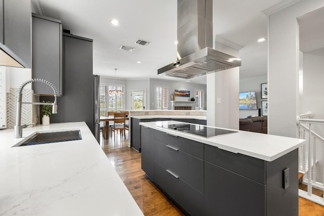 2807 Round Table Rd, Austin, TX 78746 - kitchen with extractor fan, black electric cooktop, modern cabinets, a center island, and dark cabinetry