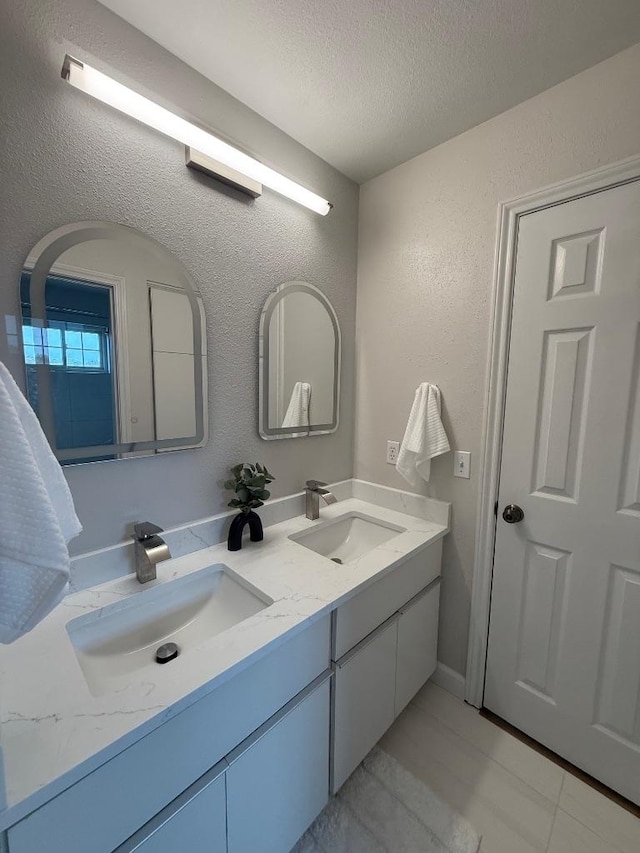 2807 Round Table Rd, Austin, TX 78746 - bathroom with double vanity, a textured ceiling, a textured wall, and tile patterned flooring