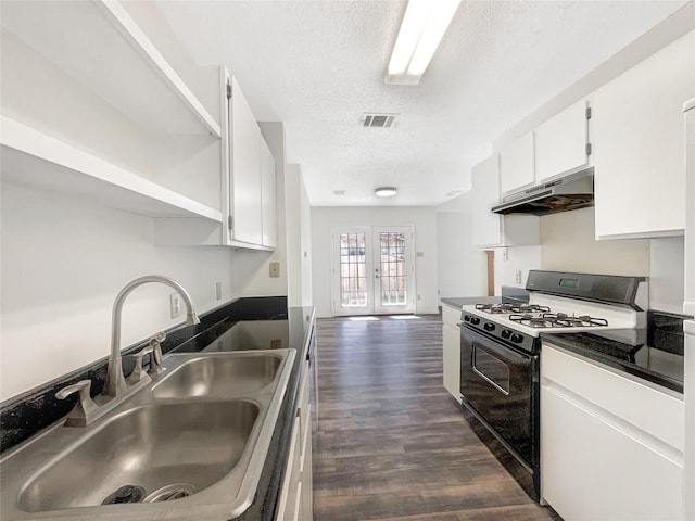 2603 Tracy Trl, Austin, TX 78728 - kitchen with black gas range oven, a textured ceiling, under cabinet range hood, open shelves, and white cabinetry