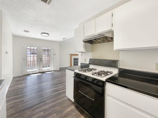 2603 Tracy Trl, Austin, TX 78728 - kitchen featuring range with gas cooktop, under cabinet range hood, dark wood-type flooring, white cabinets, and a textured ceiling