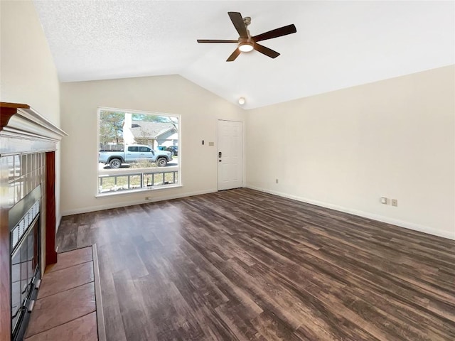 2603 Tracy Trl, Austin, TX 78728 - unfurnished living room featuring a fireplace, dark wood-style floors, ceiling fan, and vaulted ceiling